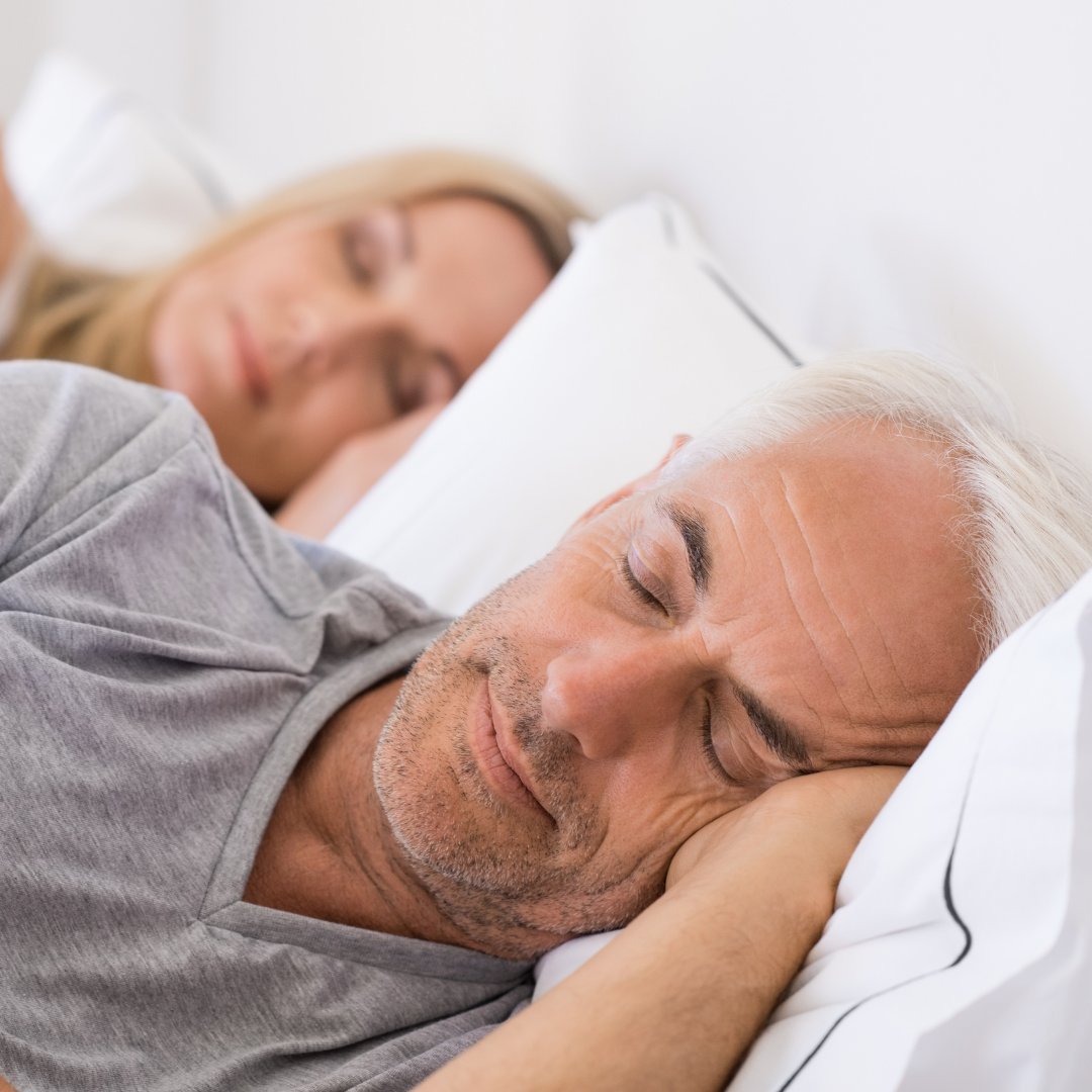 Imagem de um casal dormindo em uma cama