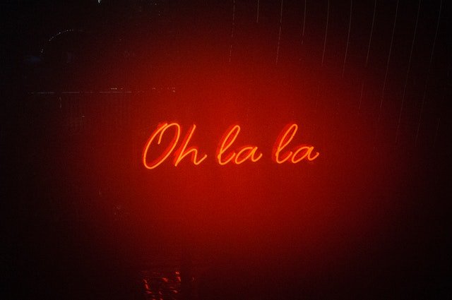 Placa neon com os escritos 'oh la la'.