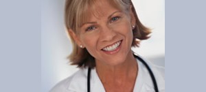 Médica sorrindo olhando para frente usando jaleco