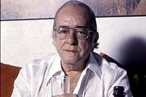 Vinicius de Moraes com copo na mão visto de frente