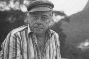 Reprodução Vinicius de Moraes usando boina e camisa de botões abertos