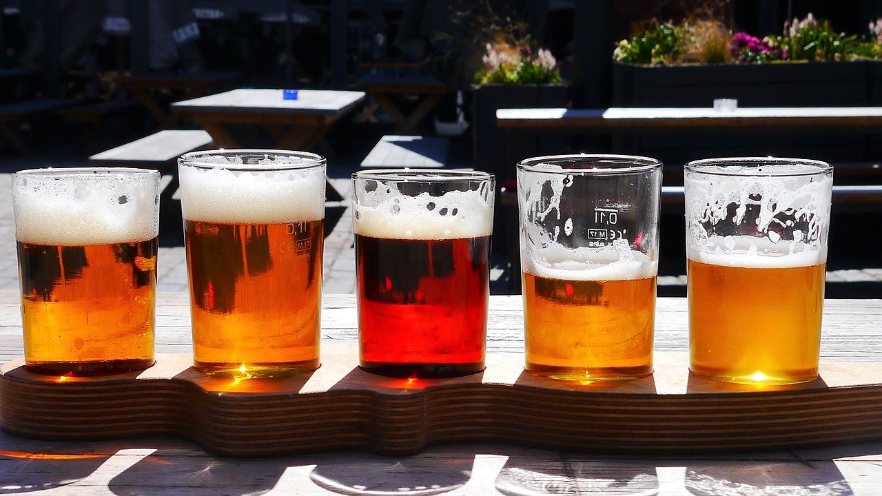 Cinco copos de cerveja cheios sobre uma mesa