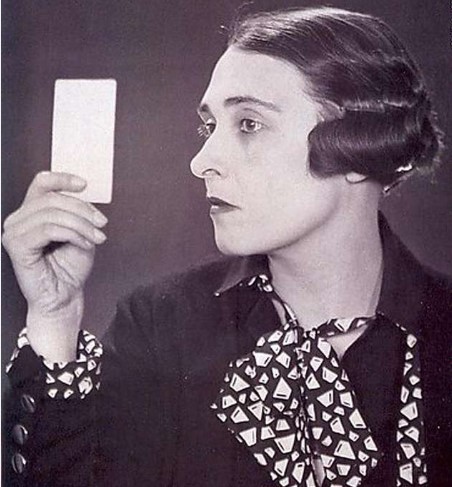 Coco Chanel olhando um pedaço de papel