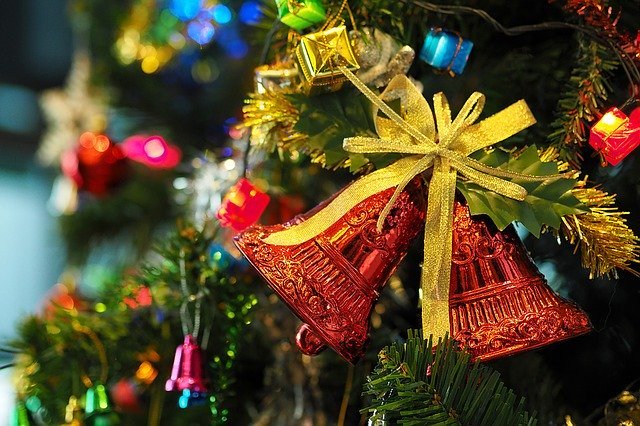 Detalhe de enfeite árvore de Natal: dois sinos vermelhos com laços amarelos.