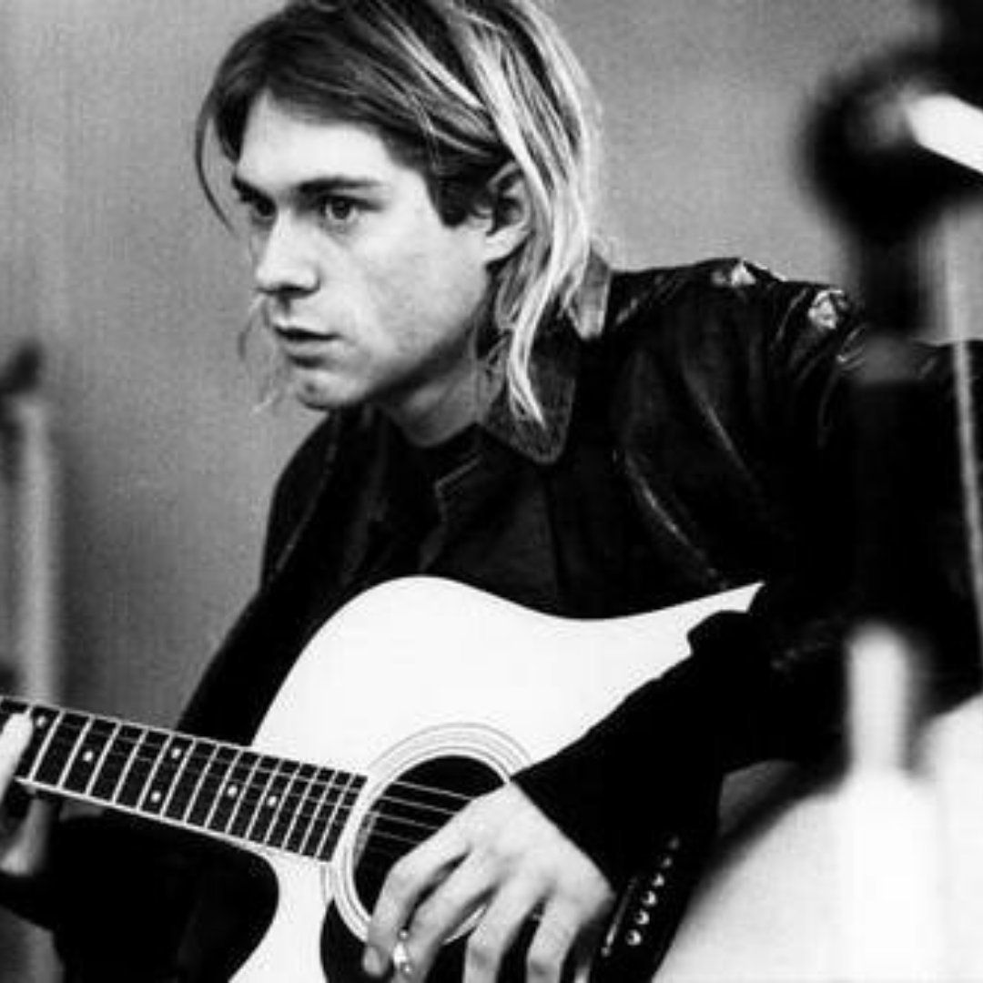 Cantor e compositor Kurt Cobain com um violão na mão