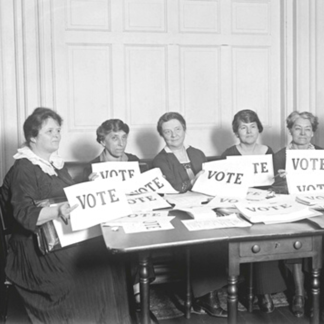 Imagem em preto e branco de mulheres segurando um cartaz com a palavra 'vote'