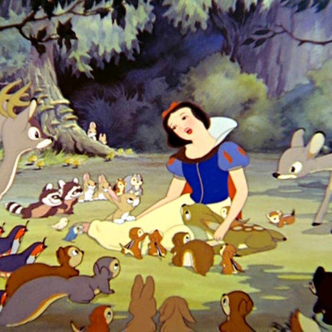 Cena do filme Branca de neve e os sete anões, em que ela está sentada cantando para os animais