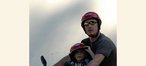 Homem com seu filho em uma moto.