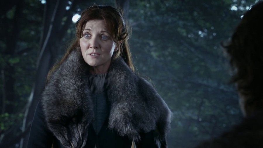 Catelyn Stark vestida com casaco de pele numa floresta