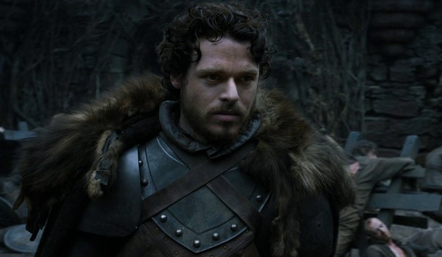 Robb Stark vestido com uma armadura olhando sério para frente