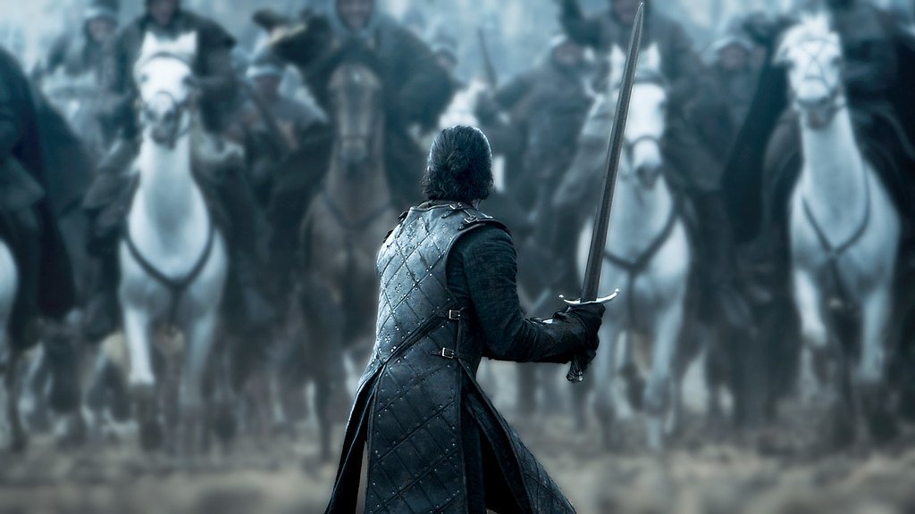 Jon Snow de costas com uma espada na mão pronto para a luta