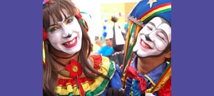 Homem e mulher um ao lado do outro com rosto pintado e sorrindo