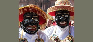 Duas pessoas usando máscaras com chapéu de palha