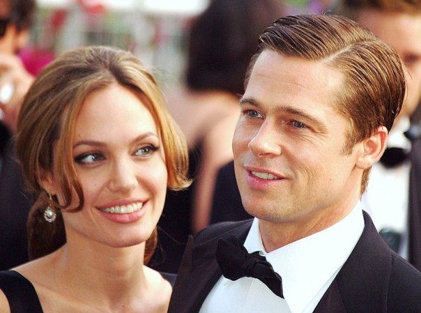 Angelina e Brad sorrindo juntos durante um tapete vermelho