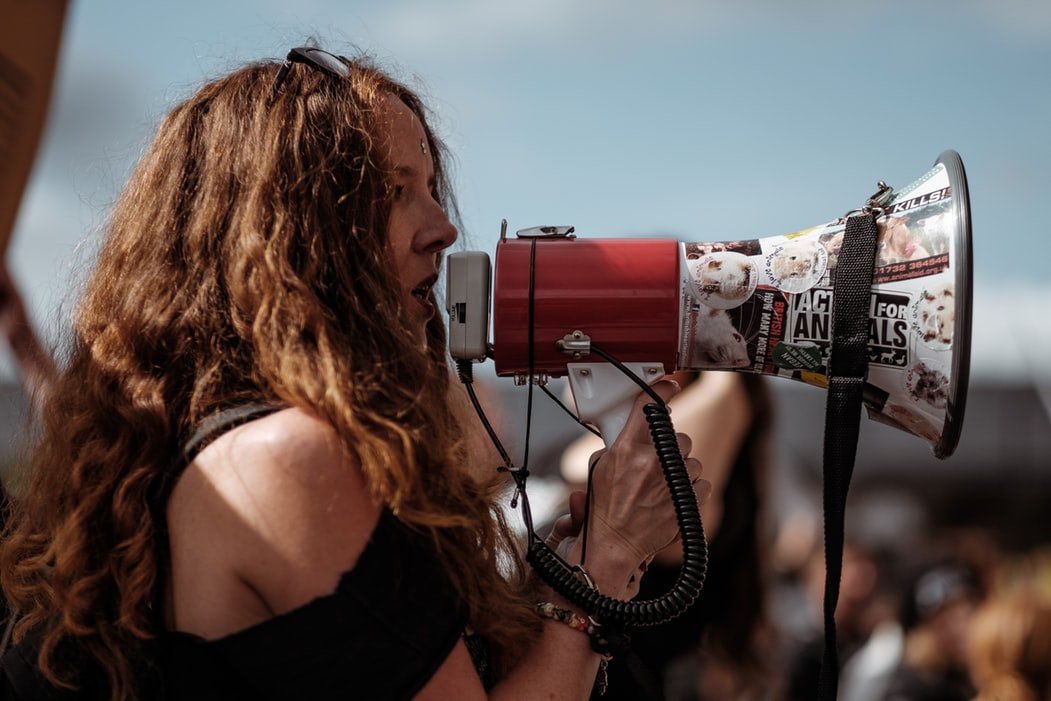 Mulher protestando com um megafone.
