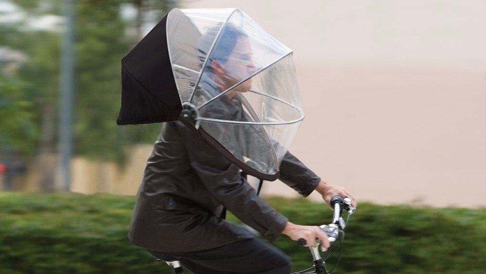Homem andando de bicicleta usando  Nubrella