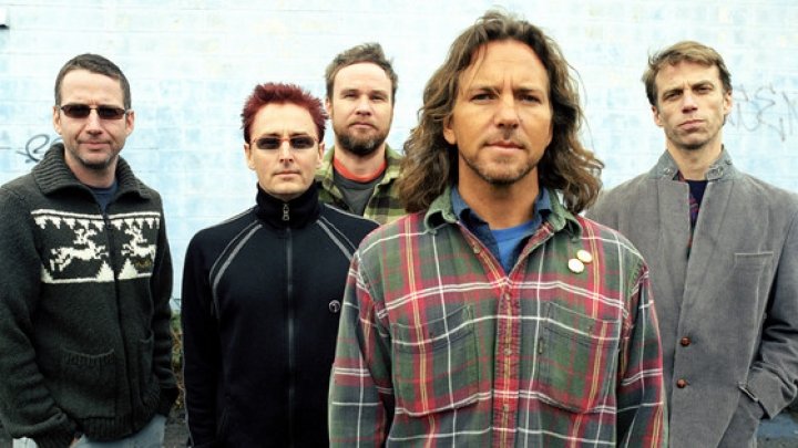 Integrantes da banda Pearl Jam com parede ao fundo