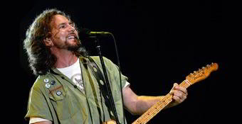Eddie Vedder tocando guitarra e sorrindo