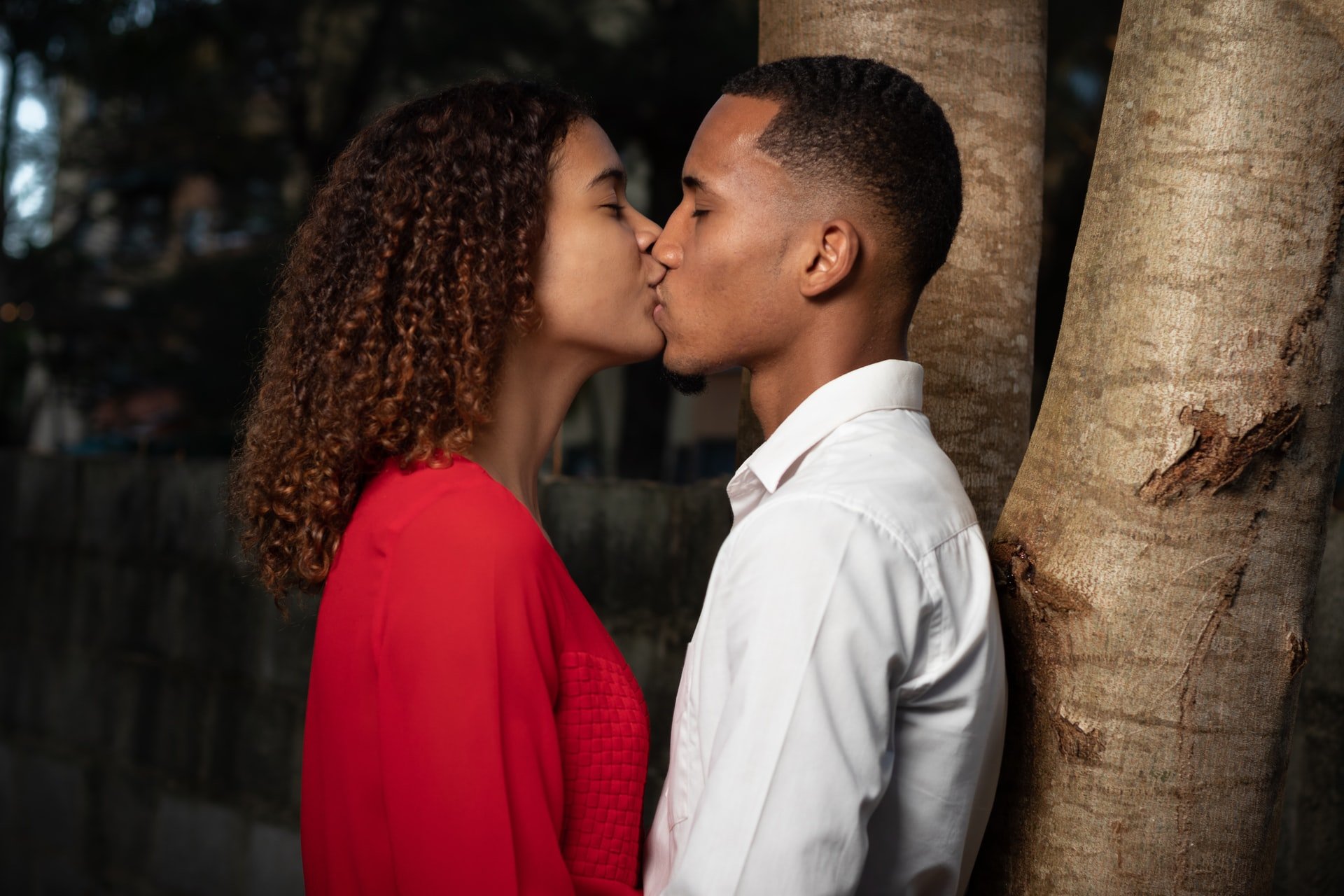 Homem e mulheres negros se beijando.
