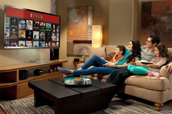 Família no sofá vendo o catálogo da Netflix.