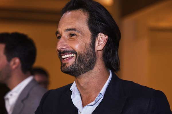 Rodrigo Santoro rindo durante evento.