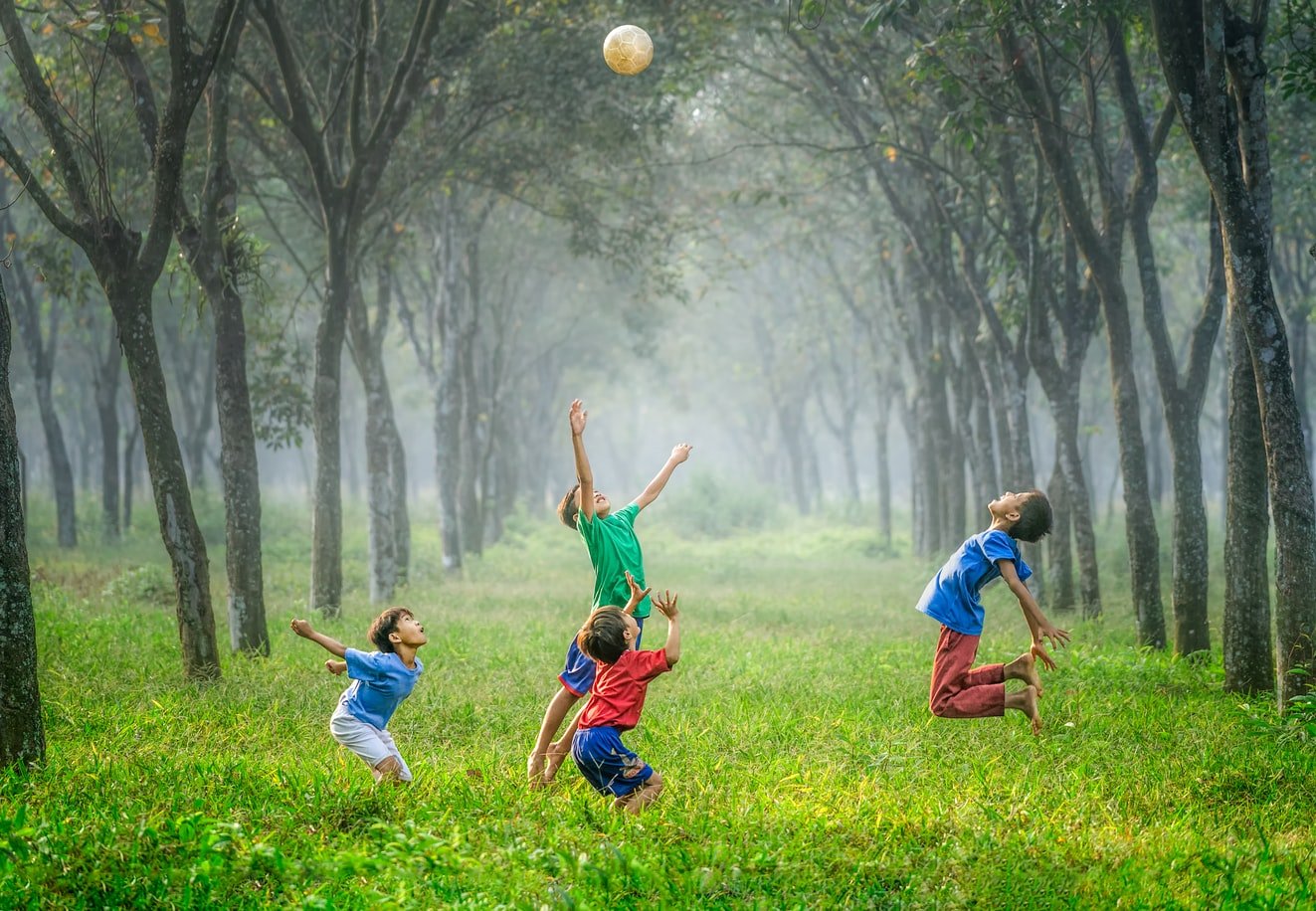 Crianças brincando com uma bola em um parque.
