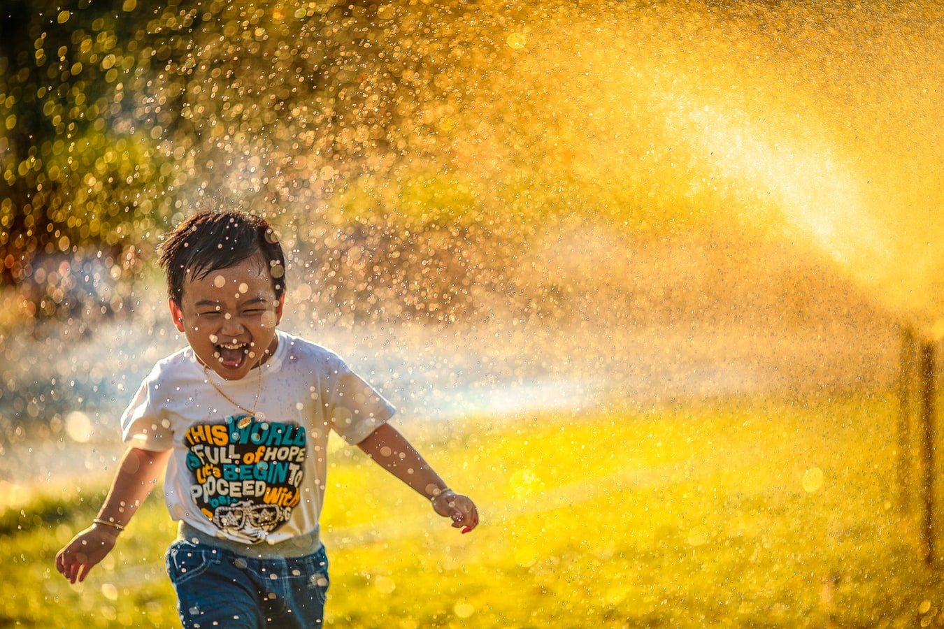 Unsplash/MI PHAM Criança brincando na chuva.