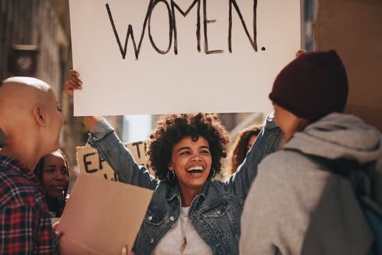 Mulher segurando cartaz escrito 'mulher' em um protesto