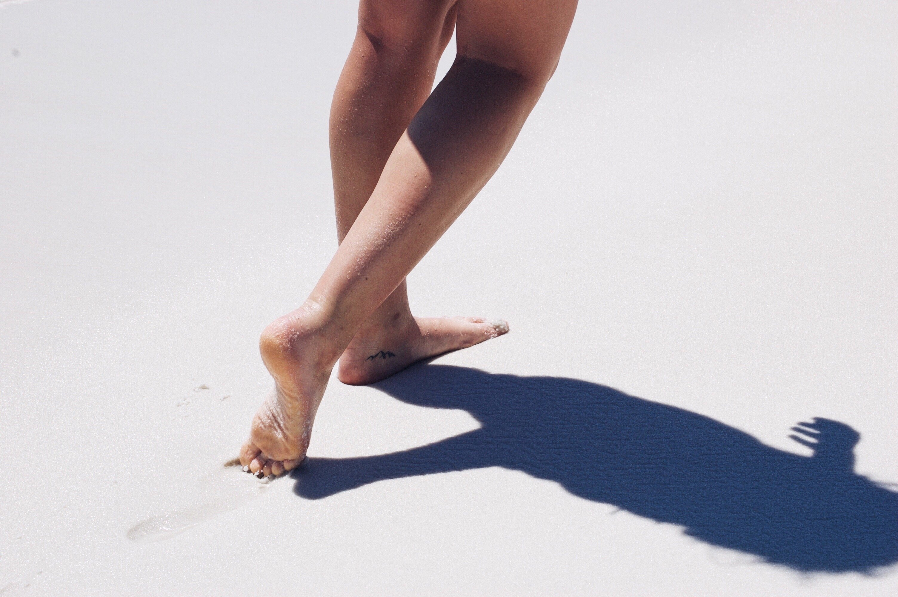 Mulher andando na areia da praia