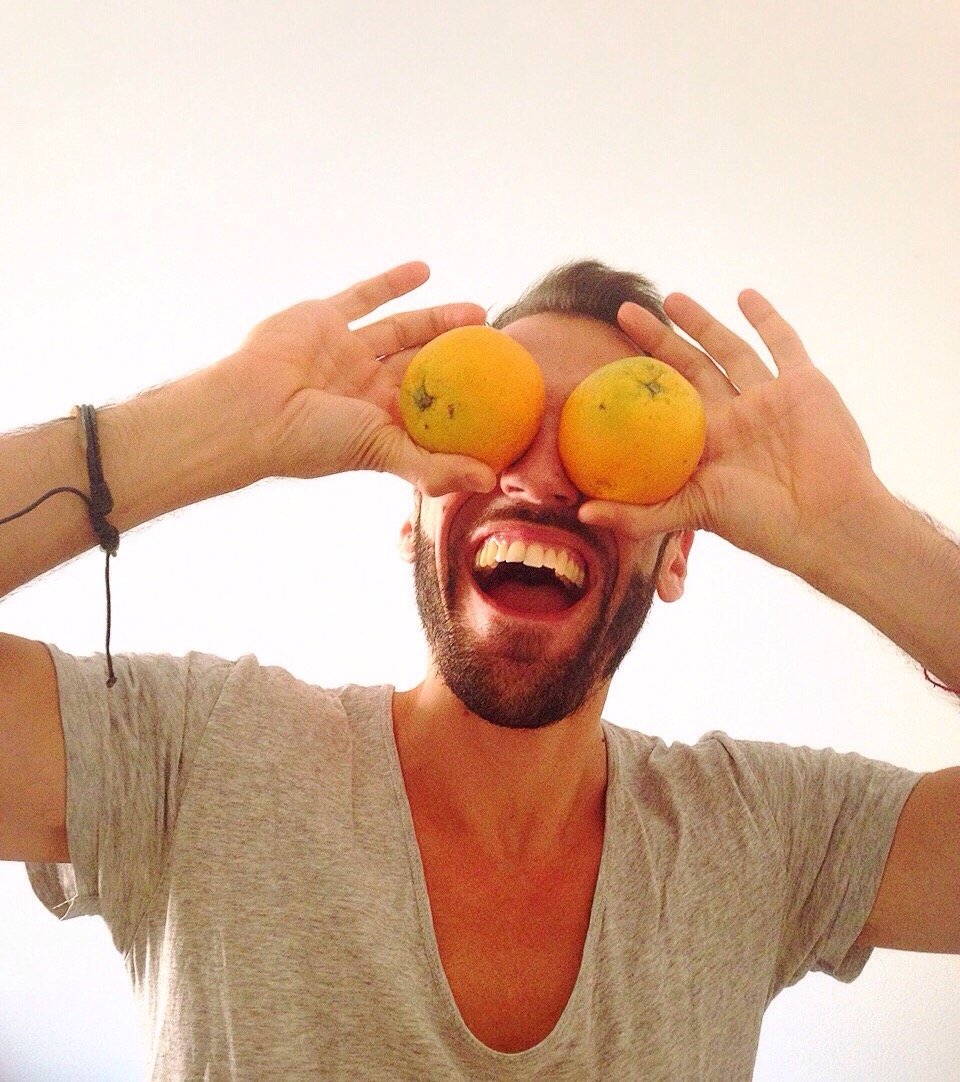 Homem com duas laranjas no olho sorrindo