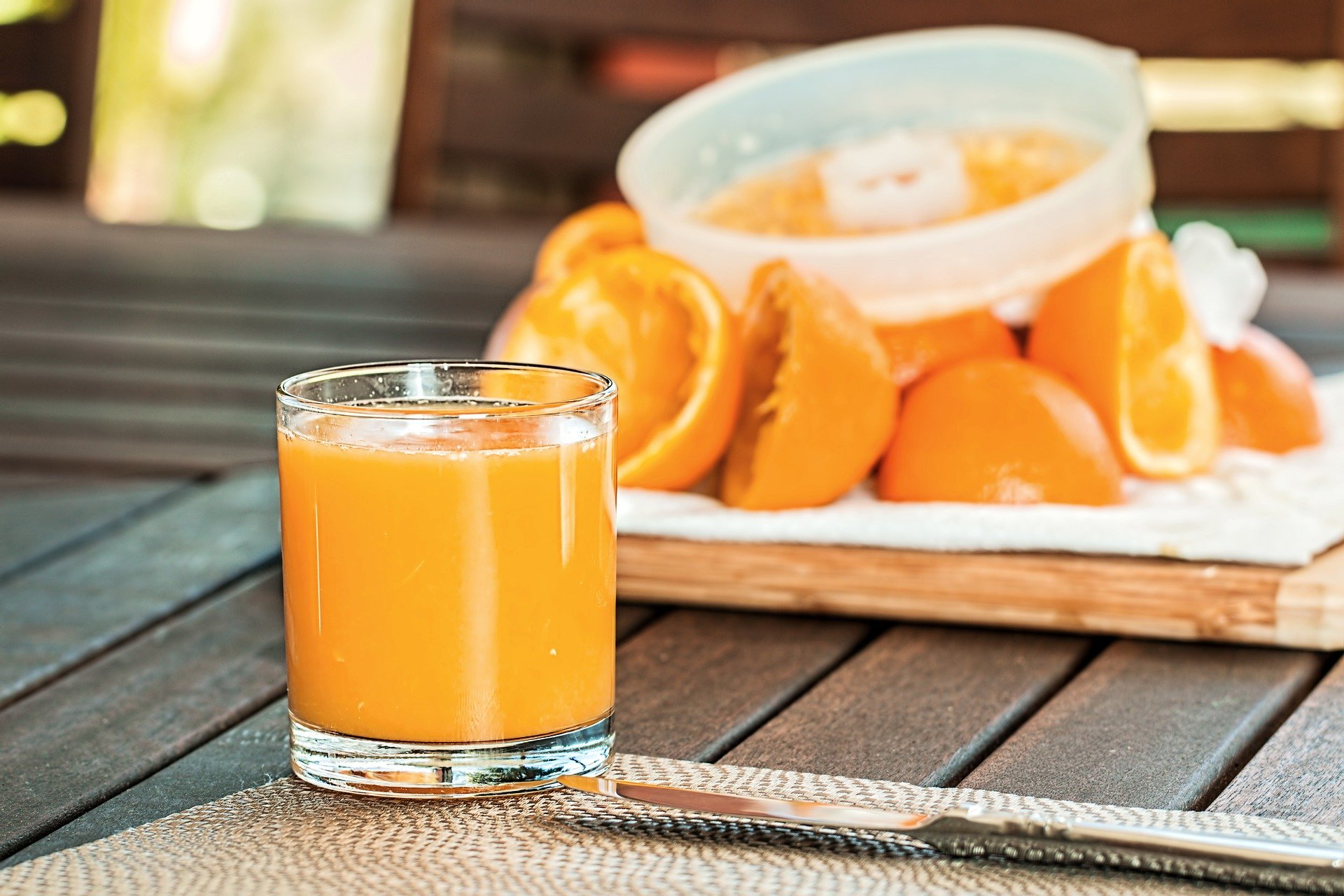 Suco natural em uma mesa com laranjas cortadas atrás