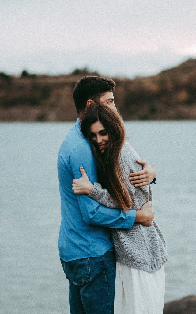 Homem e mulher abraçados sorrindo.