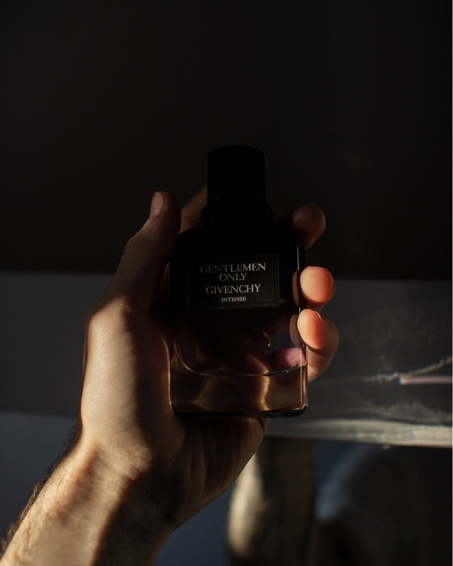 Mão de um homem segurando um perfume masculino