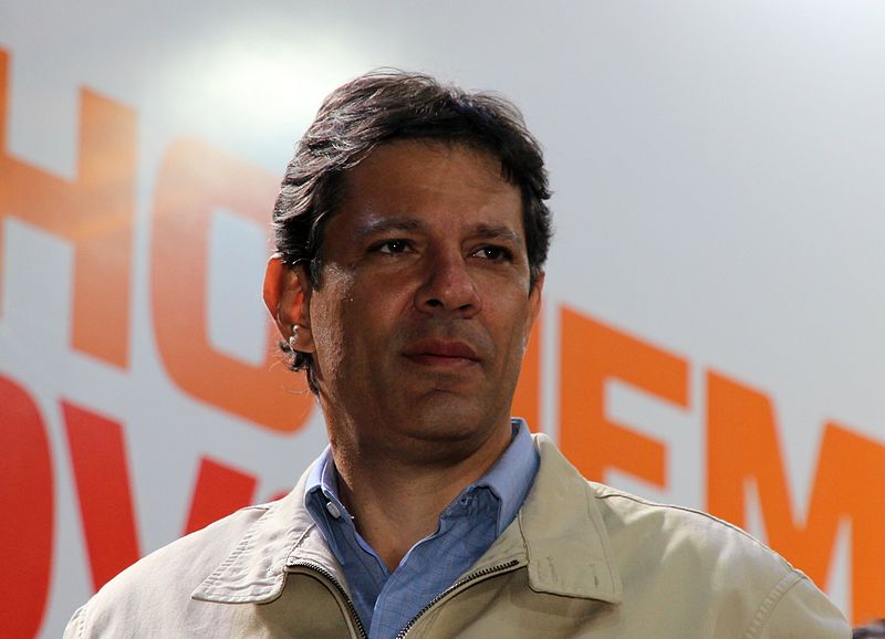 Fernando Haddad parado, com semblante sério.