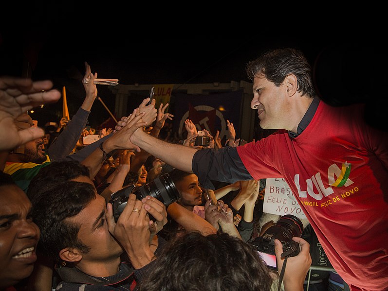 Fernando Haddad interagindo com o público em um comício pró Lula.