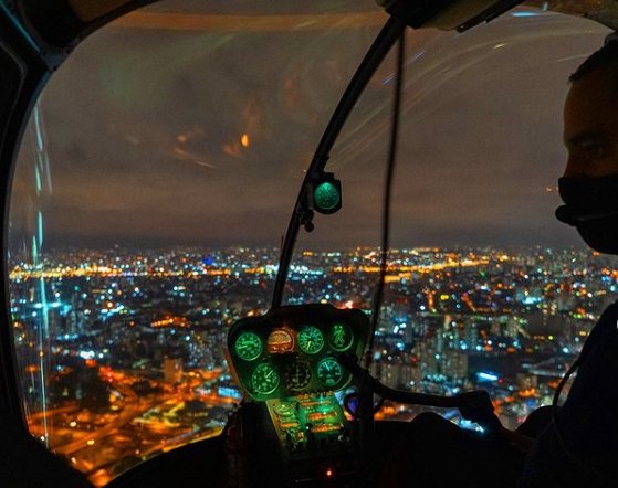 Imagem de um helicóptero voando por São Paulo.