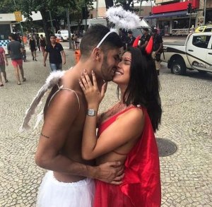 Casal vestido de anjo e demônio se beijando