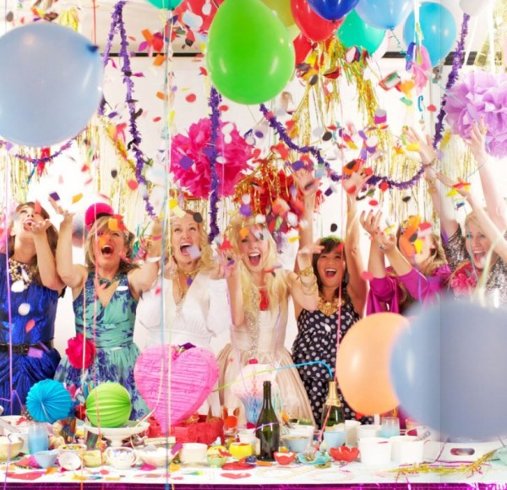 Mulheres felizes atrás de mesa com enfeites de carnaval