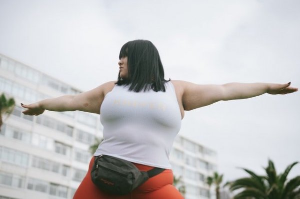 Pexels/Retha Ferguson Mulher de braços abertos para os lados, e olhando para seu lado direito. A foto está tirada de baixo para cima.