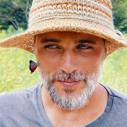 Selfie de Bruno Gagliasso com chapéu, no meio do mato