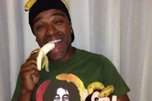 Alexandre Pires em foto comendo banana e bananas ca cabeça e no bolso em apoio à campanha #somostodosmacacos
