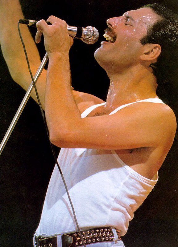 Freddie Mercury em show cantando de olhos fechados