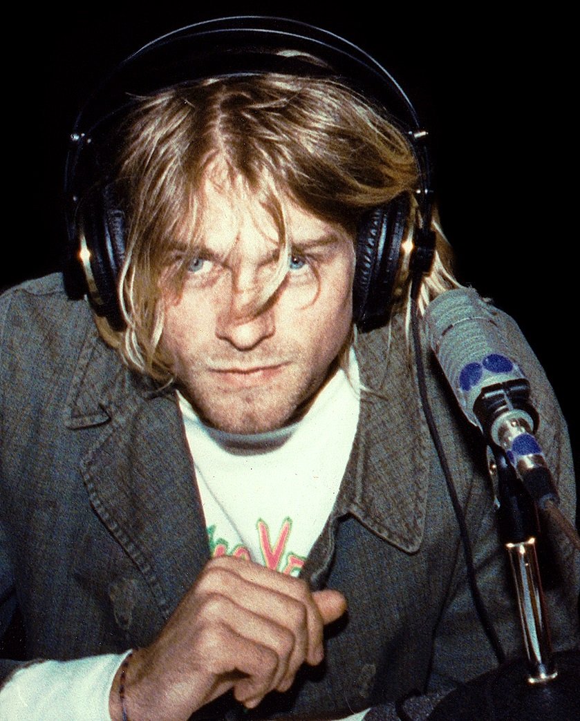 Kurt Cobain em gravação usando fones e com michrofone em frente