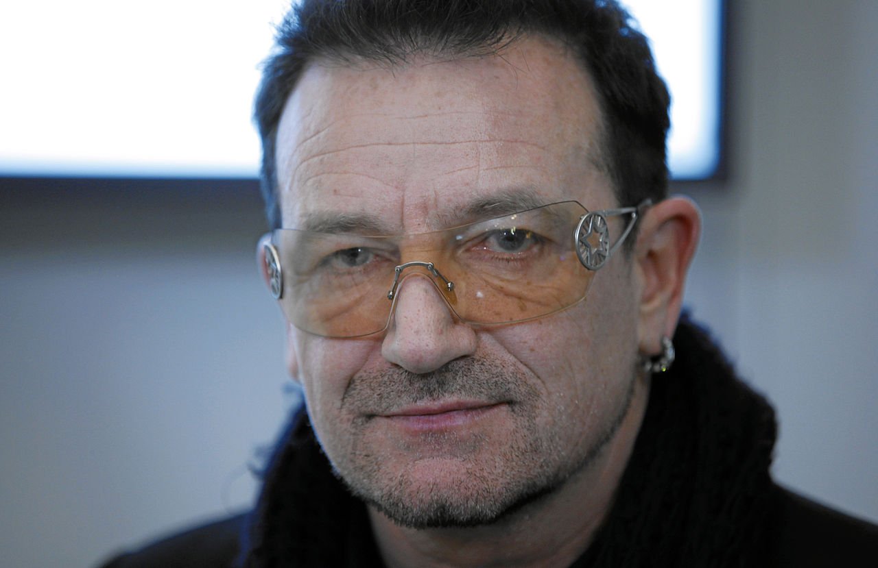 Bono Vox visto de perto usando óculos amarelo