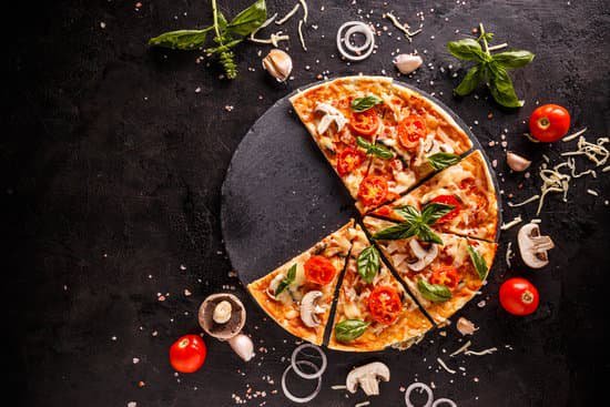 Pizza em uma mesa com ingredientes em volta