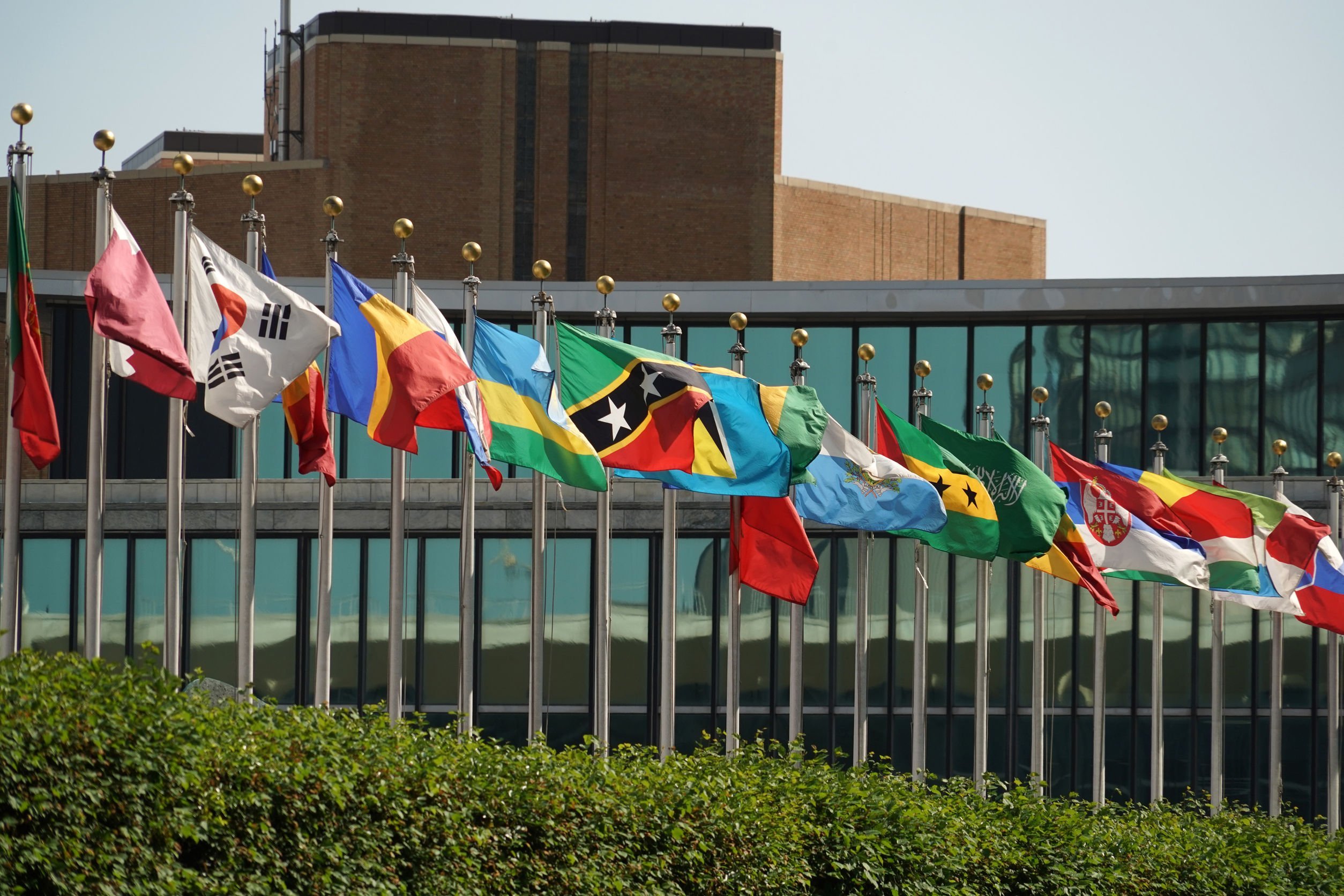 Bandeiras de países ao lado de um prédio