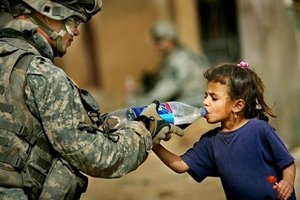 Soldado dando garrafa de água para criança