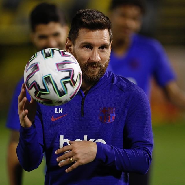 Lionel Messi segurando bola de futebol