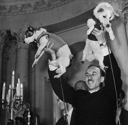 Oleg Gazenko levantando dois cachorros, um em cada mão.