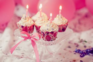 Cupcakes de aniversário com velas acesas.